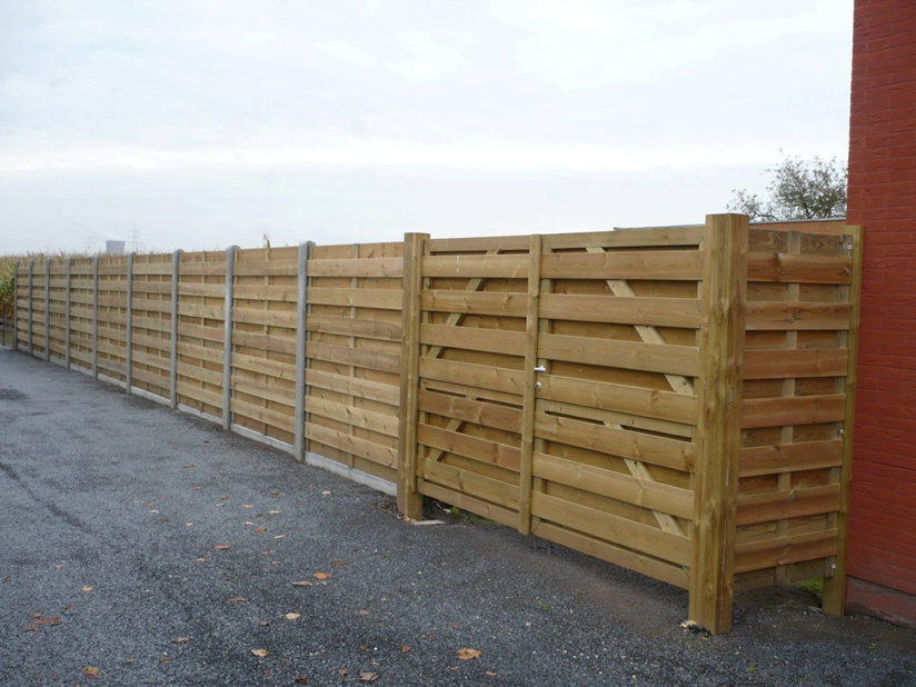 Houten afsluiting met betonnen palen en dubbele houten poort voor klant uit Oost Vlaanderen